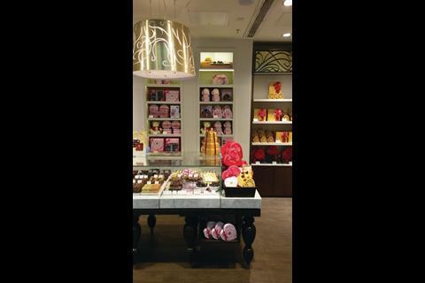 There is a large table laid out with heart-shaped chocolate boxes and piles of cream-centred confectionery.